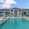 umbrella shaded tables and lounge chairs around swimming pool