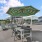 table and chairs under umbrella shading next to pool